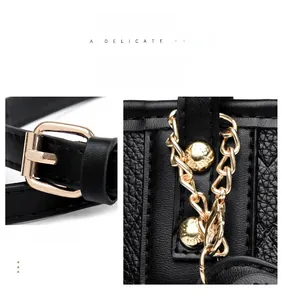 Detail of black lychee leather bag with gold buckle, chain and engraved metal studs