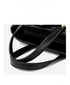 Detailed close-up of premium black crossbody bucket bag with gold studs and fine stitching