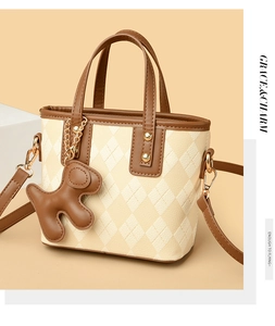 Detail of argyle bucket bag with golden hardware and cute puppy leather charm pendant