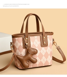 Detail of pink quilted tote bag with brown leather trim and cute puppy charm
