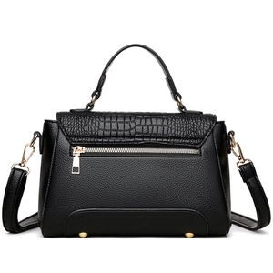 Classic black handbag with crocodile embossed leather flap and golden hardware