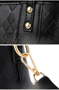 Detail of black leather bucket bag with shiny gold rivets and metal lobster clasps