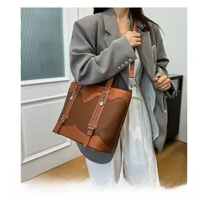 Detail of vintage color-block tote bag with metal buckles and zippers on model