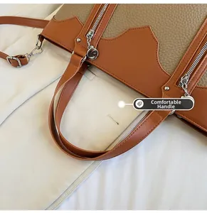 Close-up of contrast stitching and textured lychee pattern leather on tote bag handles