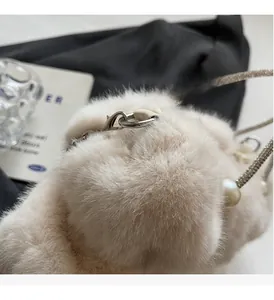 Detail of soft faux fur handbag with silver chain and white pearl handle ornament