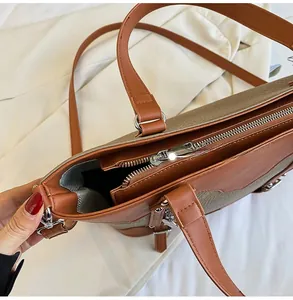Close-up of smooth metal zipper and spacious interior of the two-tone leather tote bag
