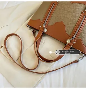 Detailed shot of adjustable shoulder strap and dual zippers on two-tone tote bag