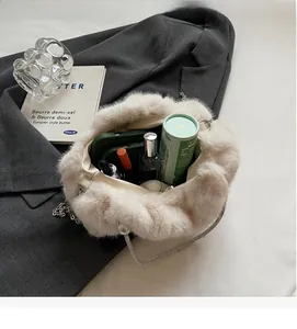 Spacious interior of plush cream bucket bag with metal chain and personal essentials