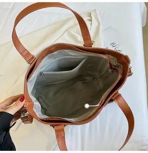 Close-up of caramel brown tote bag interior featuring grey lining and zipper pocket