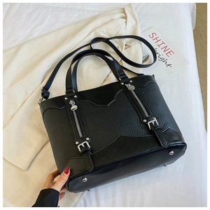 Close-up of color-block tote bag with pebble leather texture and silver buckle details