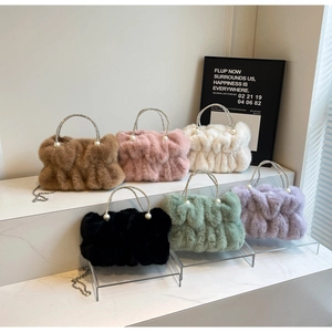 Detail of colorful faux fur cloud bags with pearl handles and metal chain straps