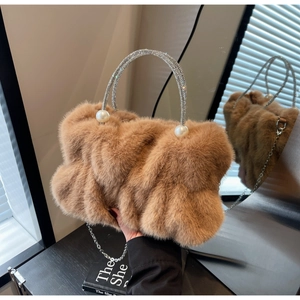 Macro view of fluffy faux fur handbag with rhinestone handle and decorative pearls
