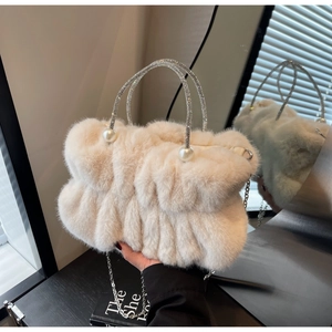 Close-up of cream faux fur bag featuring sparkling rhinestone handle and pearl accents