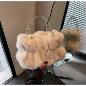 Close-up of beige faux fur cloud bag with rhinestone ring handle and pearl detail
