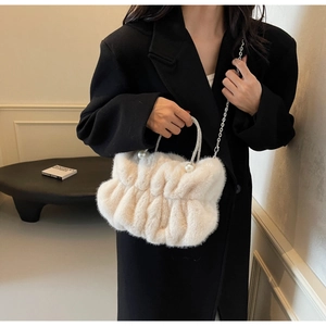 Detail of cream faux fur bag featuring pearl rhinestone handle and chain strap