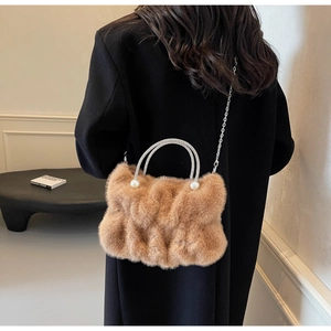 Detail of faux mink fur handbag featuring crystal handle and silver chain strap