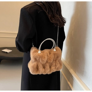 Detailed view of fuzzy brown faux fur handbag with pearl handle and metal chain strap