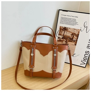 Detail view of two-tone tote bag with vertical decorative zippers and buckles
