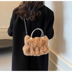 Detail of furry crossbody bag with rhinestone handle, pearl accents and silver chain