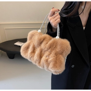 Detail of camel plush faux fur cloud bag with large pearl handle and rhinestone chain strap