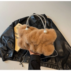 Detail of brown faux fur handbag with rhinestone handle and decorative pearls