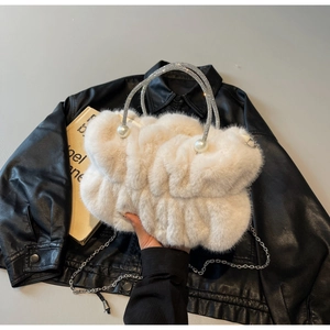 Detail of faux fur handbag featuring rhinestone handle and large pearl embellishments