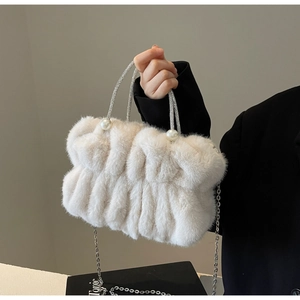 Detail of white faux fur handbag featuring pearl accents and a sparkling rhinestone handle