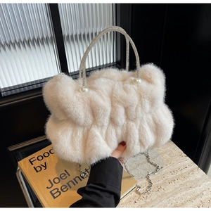 Close-up of fluffy faux fur handbag with sparkling rhinestone handle and pearl accents