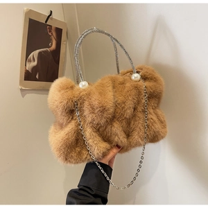 Detail of faux fur brown bag with sparkling rhinestone handle and elegant pearl accents