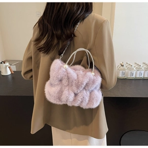 Close-up of light purple faux fur bag with rhinestone handles and pearl accents on a model