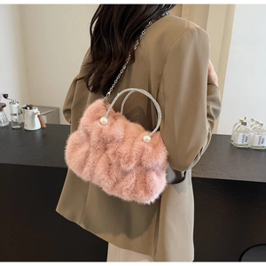 Pink faux fur bag with rhinestone ring handle and pearl detail worn on khaki blazer