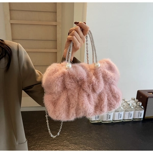 Detailed shot of pink faux fur handbag with pearl accents and a crystal-encrusted handle