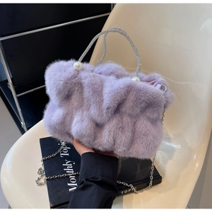 Detail of lavender faux fur handbag with pearl accents and sparkling rhinestone handle