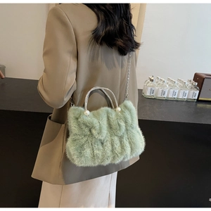 Detail of sage green faux fur bag with pearl accents and sparkling rhinestone handle