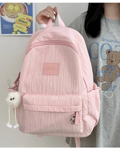 Detailed view of pink quilted school backpack with cute plush charm and fuzzy accessories