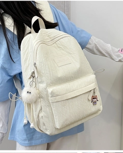 Detailed side view of a white bubble texture backpack with plush charm and logo patch