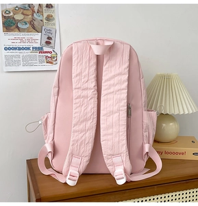 Detail of pink backpack back featuring wide shoulder straps and a hidden anti-theft pocket
