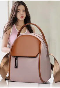Detail view of the violet-pink and brown nylon backpack with wide shoulder strap