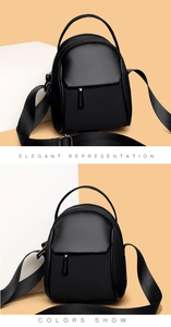 Detail of a black mini crossbody bag with a wide strap and dual zipper compartments