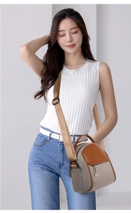 Detail of color-block mini crossbody bag with wide brown fabric strap and gray texture