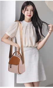 Detail of a two-tone nylon crossbody bag featuring nude pink and brown contrast colors