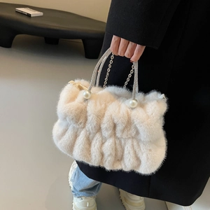 White faux fur handbag with pearl handle and rhinestone chain in a handheld view