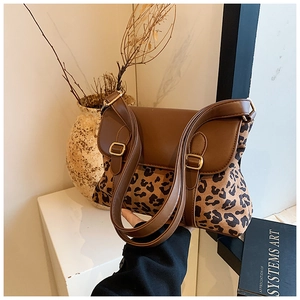 Detail of leopard print crossbody bag with dark brown leather straps and gold metal buckle