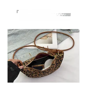Detailed interior view showing large capacity of leopard print crossbody crescent bag