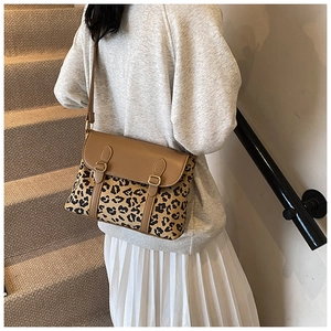 Detail shot of leopard print crossbody bag with gold metal buckles and brown flap cover