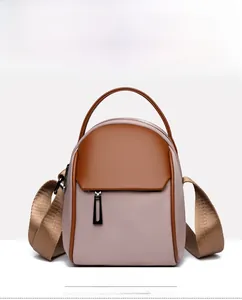 Front view of a minimalist pink PU leather mini crossbody bag with brown trim accents