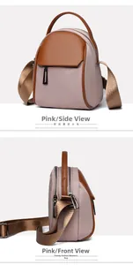 Detail view of pink color-block crossbody bag with brown leather handles and nylon texture