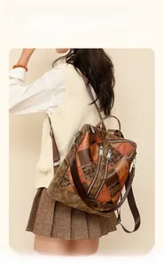 Detail of vintage patchwork leather backpack with metal zippers and elegant brown finish