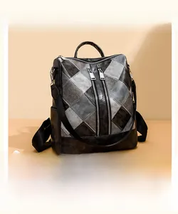 Detail view of multi-purpose backpack featuring faux leather geometric patchwork and dual zippers