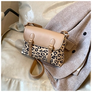 Detail of retro leopard print crossbody bag with khaki leather flap on grey texture